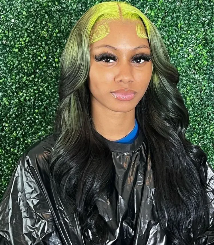 Woman with long black glam waves and chartreuse-green color framing the front roots.